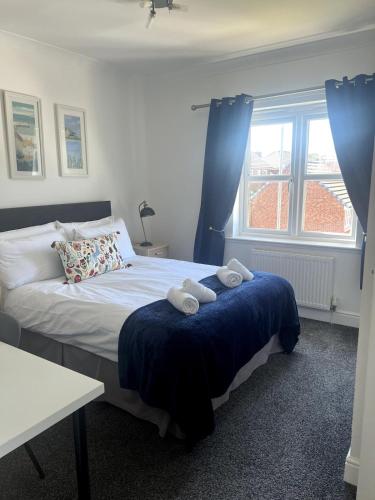 a bedroom with a bed with two towels on it at Meadow House- Driveway Parking and Fireplace in East Kilbride