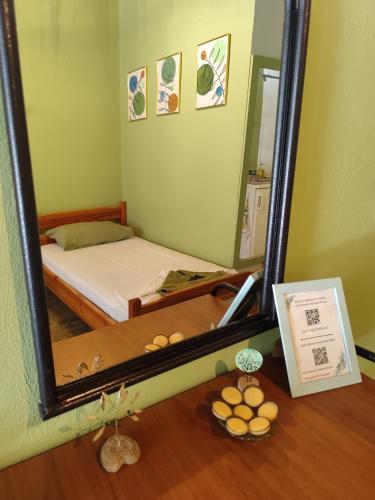 a mirror on a table with a bed in a room at Asmanis Rooms in Tarti