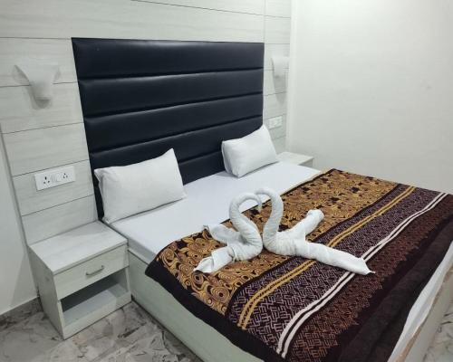 a bedroom with a bed with two white towels at Pacific Inn Mussoorie in Mussoorie