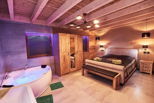 a bathroom with a bath tub and a bed at Wellness Ferienhaus “Lotus II” in Rieden