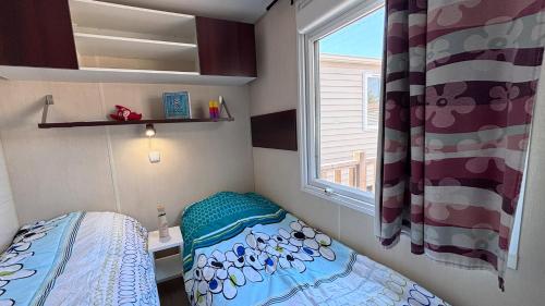 une petite chambre avec un lit et une fenêtre dans l'établissement Camping Tikayan Félix de la Bastide, à Saint-Mitre-les-Remparts