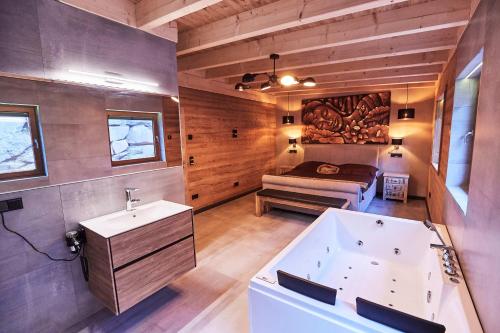 a bathroom with a tub and a bed in a room at Wellness Ferienhaus “Lotus I” in Rieden