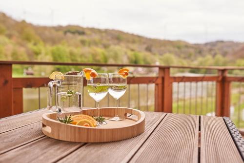 een dienblad met wijnglazen op een houten tafel bij Ferienwohnung Mila OG in Rieden