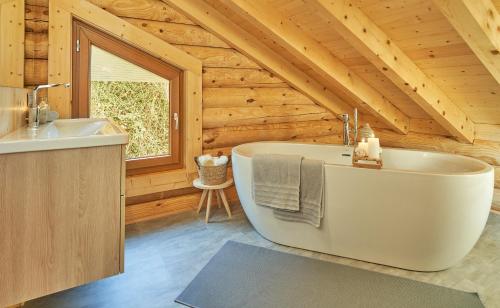 a bathroom with a tub and a sink at Seezeit Chalet in Rieden