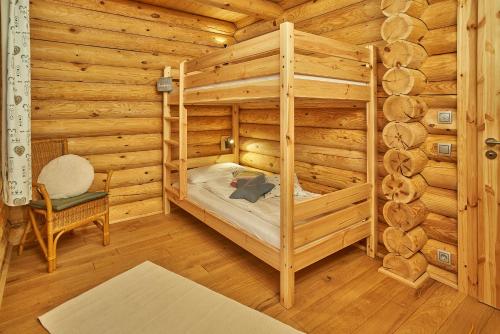 a log cabin bedroom with a bunk bed and a chair at Seezeit Chalet in Rieden