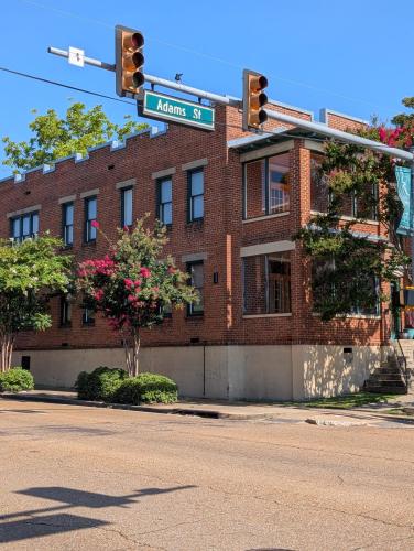 a street sign on a traffic light in front of a brick building at Historic Upscale Loft in Downtown Vicksburg! in Vicksburg