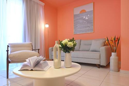 a living room with a couch and a table with flowers at Come Si Deve City Apartments, by Zantewize in Zakynthos Town
