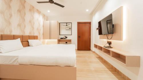 a bedroom with a bed and a flat screen tv at Flare By Blaze in Bhopal