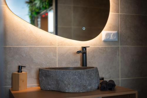 a bathroom with a stone sink and a mirror at Love room Aubagne in Aubagne