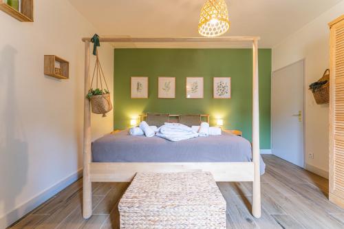 a bedroom with a bed and a green wall at Domaine du Flamand - Gîtes du Pin Sec côté OCEAN in Naujac-sur-Mer