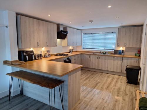 a large kitchen with wooden cabinets and a counter top at Coastal 3BR Garden & Parking in Eastbourne