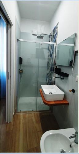 a bathroom with a glass shower and a sink at B&B Su PRESSIU in Narbolia