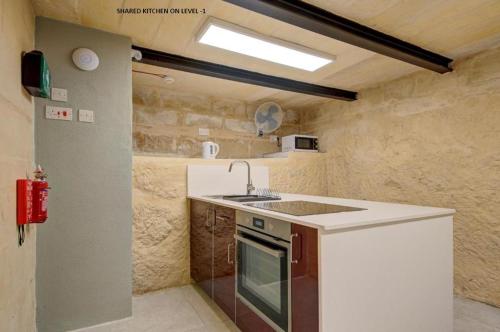 a small kitchen with a sink and a stove at Casa San Domenico 3 by Vallettastay in Valletta
