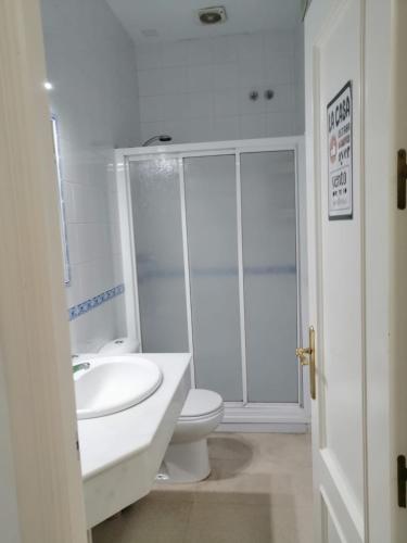Un baño blanco con inodoro y lavabo. en Piso centro de Cádiz, en Cádiz