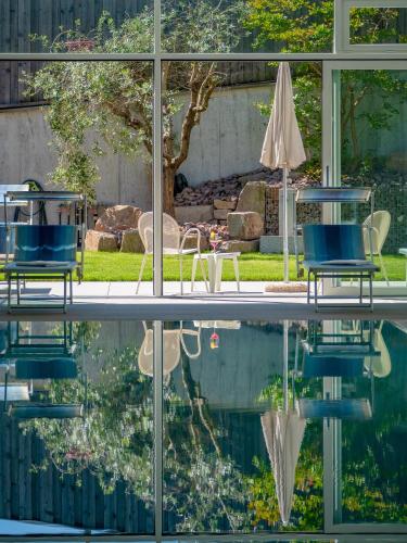 two chairs and an umbrella sitting next to a pool at Garni Hotel Sonnleitenhof in Caldaro