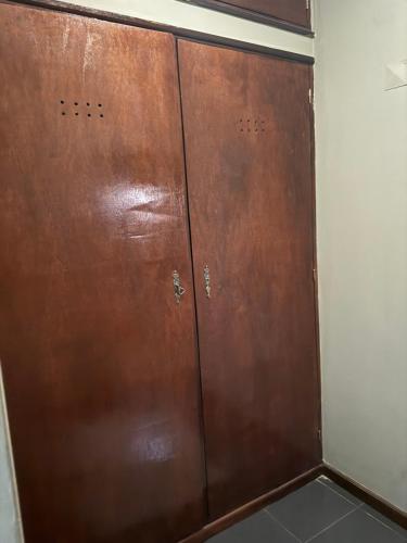two brown doors in a room with a wall at TR CASA DE AcCOMODAÇÃO in Matola