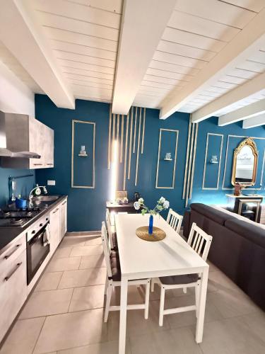 a kitchen with blue walls and a white table and chairs at AMA Esclusive SPA Bologna in Bologna