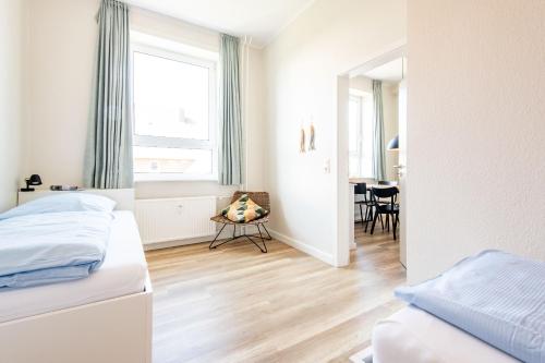 a bedroom with two beds and a dining room at Steger-Hüs Wohnung 25 in Rantum