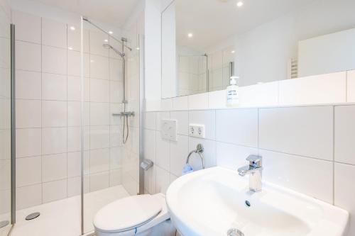 a bathroom with a sink and a toilet and a shower at Steger-Hüs Wohnung 41 in Rantum