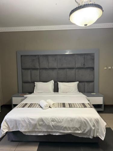 a bedroom with a large bed with two towels on it at TR CASA DE AcCOMODAÇÃO in Matola