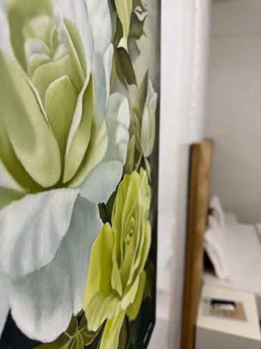 a vase with green flowers on a wall at TR CASA DE AcCOMODAÇÃO in Matola