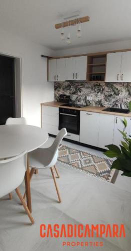 a kitchen with a white table and chairs in a room at Casa di Campara Villa in Neum