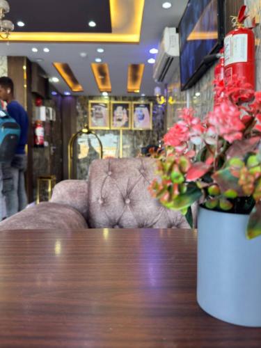 a table with a vase of flowers and a couch at سحاب الأندلس للشقق المخدومة 1 أملج Sahab Al Andalus for Served Apartments in Umm Lujj