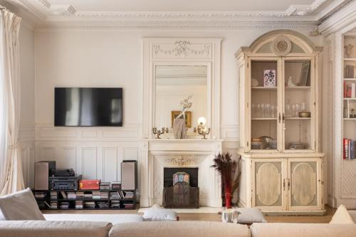 Elle comprend un salon avec une cheminée et une télévision murale. dans l'établissement Luxurious 4 Bedroom Apartment next to The Eiffel Tower, à Paris