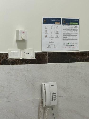 a white phone on a wall in a bathroom at سحاب الأندلس للشقق المخدومة 1 أملج Sahab Al Andalus for Served Apartments in Umm Lujj