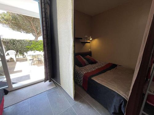 - une chambre avec un lit et une porte donnant sur une terrasse dans l'établissement Studio cosy avec terrasse, parking privé, à 300m de la plage - Saint-Hilaire-de-Riez - FR-1-224C-236, à Saint-Hilaire-de-Riez