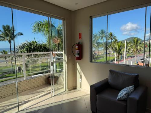 a living room with a couch and a large window at Pousada Cantinho Oriental in Bertioga