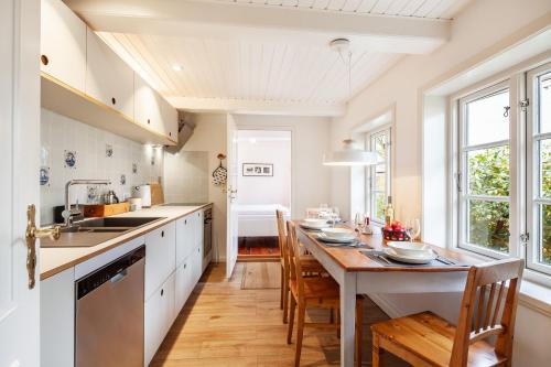 a kitchen with a table and chairs and a sink at Letj Lindguard in Alkersum