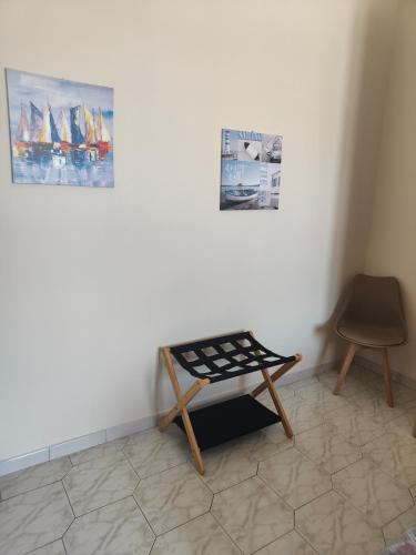 a room with a table and a chair and pictures at Hyria Intero Appartamento in centro città in Avellino