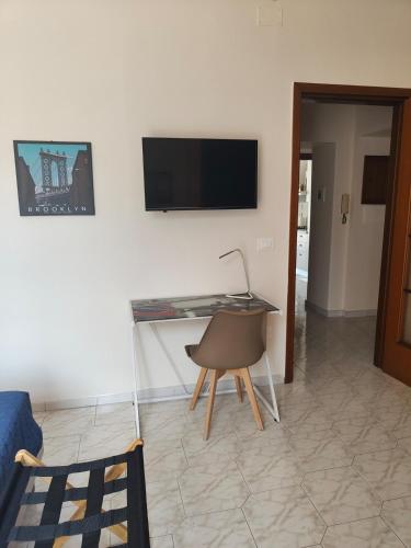 a living room with a desk and a television on a wall at Hyria Intero Appartamento in centro città in Avellino