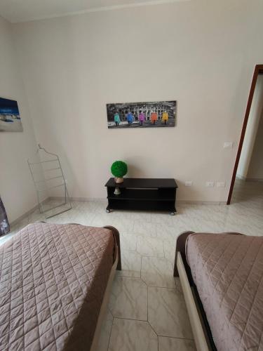 a bedroom with two beds and a table with a plant at Hyria Intero Appartamento in centro città in Avellino