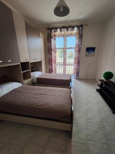 a bedroom with two beds and a window at Hyria Intero Appartamento in centro città in Avellino