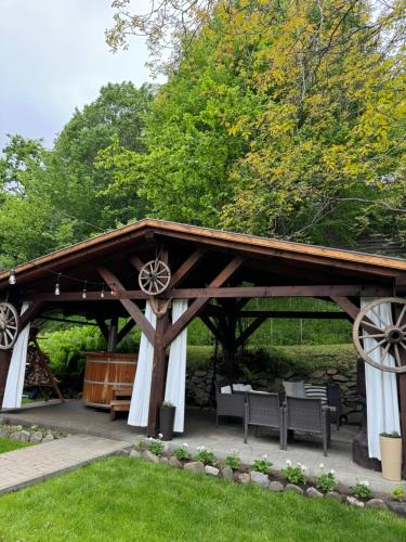 a pavilion in a park with benches and trees at Emerald Chalet in Praid
