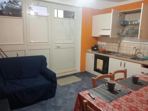 a kitchen with a table and a blue couch in a room at Apartment Vinisio a Maratea in Maratea