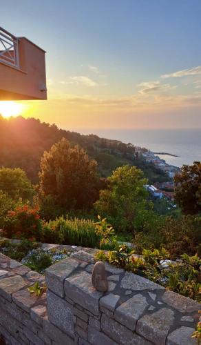 a stone wall with the sunset in the background at Apartments Zafiria in Ágios Konstantínos