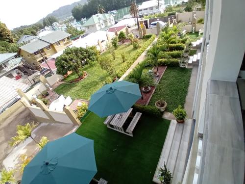 an aerial view of a yard with two blue umbrellas at La Residence D'Almee Guesthouse in Anse Possession