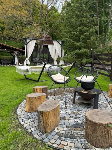 a patio with a table and chairs and logs at Emerald Chalet in Praid