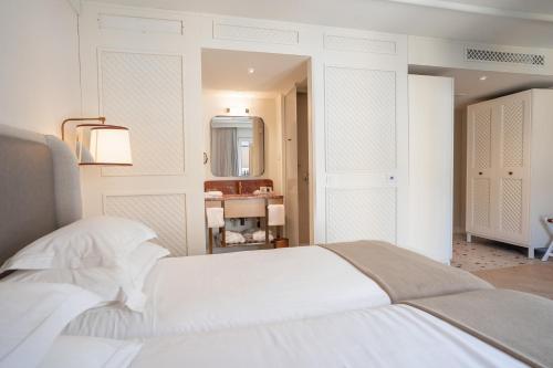 a bedroom with a white bed and a mirror at Amadria Park Grand Hotel 4 Opatijska Cvijeta in Opatija