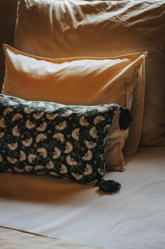 a pillow sitting on a bed next to two pillows at Drewniane Domki Całoroczne Gryszczeniówka in Wargowo