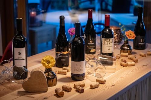 a table topped with bottles of wine and wine glasses at Tirolerhof Pension in Naz-Sciaves