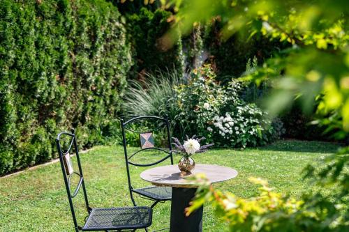 a table with two chairs and a vase with flowers on it at Tirolerhof Pension in Naz-Sciaves