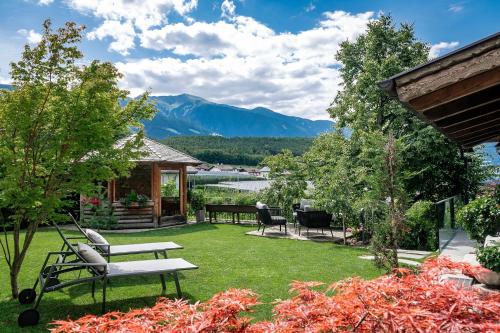 a backyard with a bench and a table and chairs at Tirolerhof Pension in Naz-Sciaves