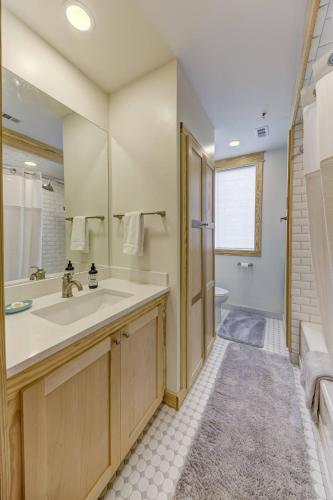 a bathroom with a sink and a mirror and a tub at Historic Upscale Loft in Downtown Vicksburg! in Vicksburg