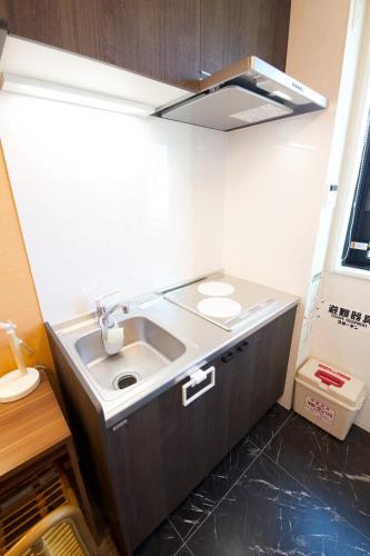 a kitchen with a sink and a counter top at TOMALCO INN NAKANO 1 4F Flat 2 Bath 13min to Shinjuku from Honancho in Tokyo