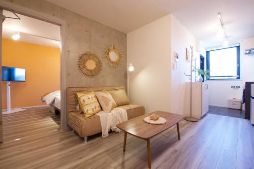 a living room with a couch and a table at TOMALCO INN NAKANO 1 4F Flat 2 Bath 13min to Shinjuku from Honancho in Tokyo