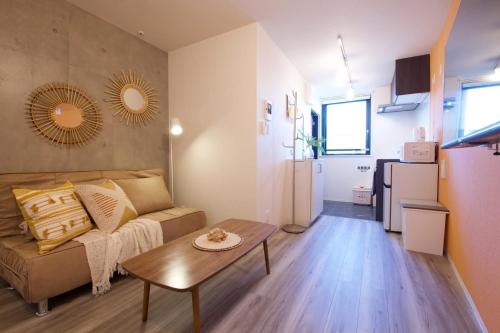a living room with a couch and a table at TOMALCO INN NAKANO 1 4F Flat 2 Bath 13min to Shinjuku from Honancho in Tokyo